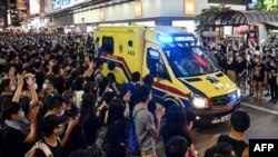 Manifestantes contra la Ley de Extradición escoltan una ambulancia