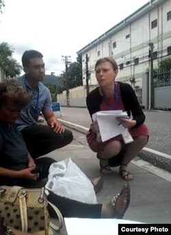 Una funcionaria de ACNUR entrega la carta a los refugiados cubanos.