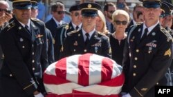 Miembros d ela Guardia Nacional de Arizona, junto a la viuda del senador, acompañan el féretro de John McCain.