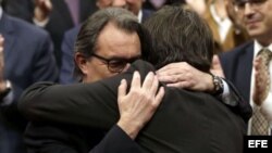 El presidente de la Generalitat saliente, Artur Mas, abraza a su sucesor, Carles Piugdemont.