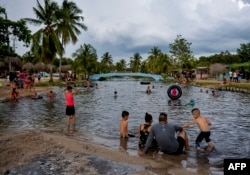 Cubanos disfrutan de la playa en Mayabeque. YAMIL LAGE / AFP