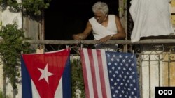 Un hombre coloca las banderas de EE.UU. y Cuba.