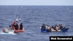 Guardacostas del escampavías Kathleen Moore interceptan un bote con balseros cubanos en aguas de la Florida.