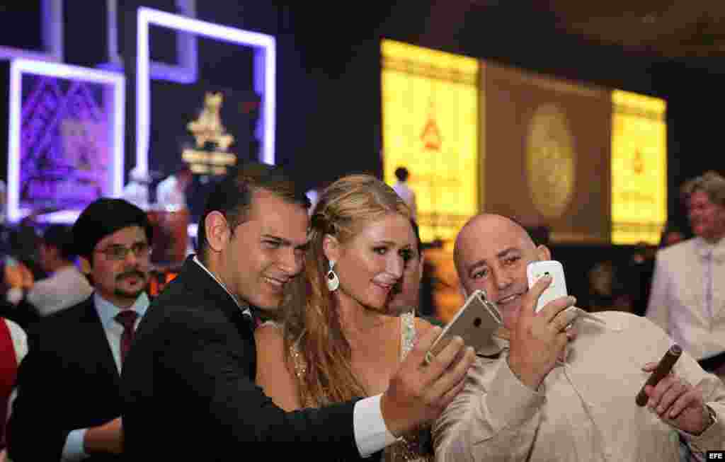 La celebridad estadounidense Paris Hilton (c), heredera del imperio hotelero de su apellido, posa con dos asistentes a su llegada a la cena de gala que cerró el XVII Festival Internacional del Habano.&nbsp;