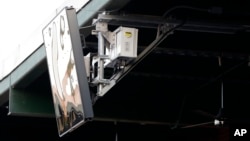 Un dispositivo de radar emplazado en el techo del PeoplesBank Park de York, Pensilvania, como parte de un sistema de "umpire robot" estrenado en el Juego de Estrellas. Foto AP/Julio Cortez.