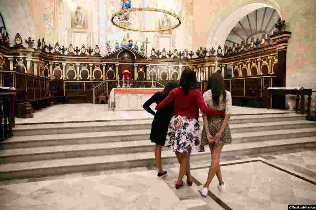 La Primera Dama de EE.UU.. Michelle Obama, y sus hijas Sasha y Malia conemplan el altar de la Catedral de La Habana (White House)