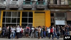 Cubanos hacen una larga fila para comprar pan en La Habana. 