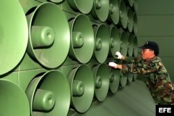 Fotografía de archivo tomada el 16 de junio de 2004 que muestra a un soldado surcoreano que retira altavoces de la zona desmilitarizada en Paju, al norte de Seúl.
