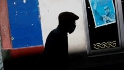 Un hombre con mascarilla pasa frente a un afiche del fallecido dictador cubano Fidel Castro, en La Habana. (REUTERS/Stringer)