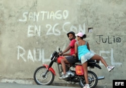Una mujer se sube en una moto en la ciudad de Santiago de Cuba.