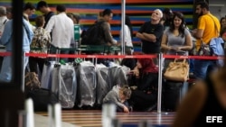 Un grupo de personas aguardando para realizar el chequeo de sus vuelos en el aeropuerto internacional "Simón Bolivar", en La Guaira (Venezuela). Foto Archivo.