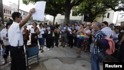 Cubanos frente a SINA en La Habana esperan por trámites para nueva ley migratoria