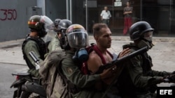 Agentes de la Guardia Nacional Bolivariana detienen a manifestantes hoy, lunes 22 de mayo de 2017, en Caracas (Venezuela)