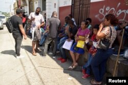 Migrantes de Cuba y Centroamérica hacen fila frente a la Comisión de Asistencia a Refugiados (COMAR) para aplicar al asilo y el estatus de refugiado en México.