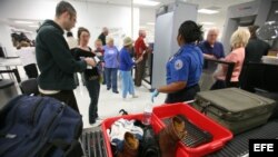 Pasajeros pasan el control de seguridad en el aeropuerto internacional de Miami. (Archivo)