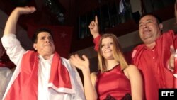 El presidente paraguayo electo, Horacio Cartes (i), saluda a seguidores junto a su vicepresidente, Juan Afara (d), y acompañado de su hija Sol (c).