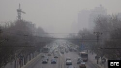 Vista del humo de los carros sobre el tráfico en el centro de Beijing (China), 12 marzo de 2008