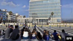 Periodistas y curiosos aguardan frente a la Embajada de Estados Unidos en Cuba en La Habana