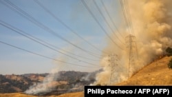 Líneas eléctricas amenazadas fue las llamas en California, 26 de octubre de 2019. 