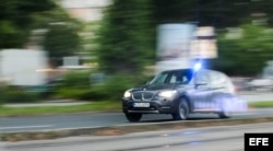 Un coche de policía circula a toda velocidad junto al centro comercial donde se ha producido un tiroteo en Múnich, Alemania hoy, 22 de julio de 2016.