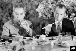Fotografía de archivo del 28 de febrero de 1972 del entonces presidente de Estados Unidos Richard Nixon, derecha, mientras come con palillos con el entonces premier chino Chou En-lai en Shanghái, China.