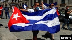 Un hombre sostiene una bandera cubana durante una manifestación, convocada por el grupo disidente cubano Prisoners Defenders, en apoyo de las protestas contra el gobierno en Cuba, frente al parlamento español en Madrid, España, el 12 de julio de 2021. REU