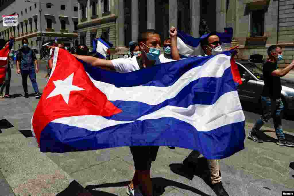 Un hombre sostiene una bandera cubana durante una manifestación, convocada por el grupo disidente cubano Prisoners Defenders, en apoyo de las protestas contra el gobierno en Cuba, frente al parlamento español en Madrid, España, el 12 de julio de 2021. Foto: REUTERS/Javier Barbancho.