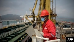 Trabajador de PDVSA observa un carguero de petróleo. (AFP).