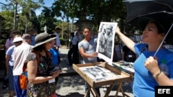 Una guía muestra a turistas una foto con la imagen de Fidel Castro junto al escritor Ernest Hemingway.