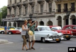 Una pareja de turistas camina por una calle de La Habana.