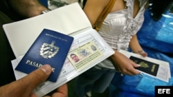 Un hombre muestra su pasaporte en el aeropuerto Internacional de Miami (EEUU) antes de viajar a Cuba.