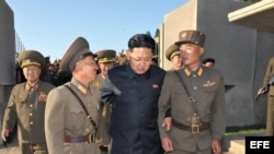 El líder norcoreano Kim Jong-un (c) mientras camina con dos soldados en el islote Wolnae. 