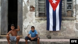 Dos niños posan frente a una casa en ruinas en Santiago de Cuba. EFE