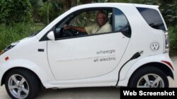 El propietario de Cayman Automotive posa junto a uno de sus autos eléctricos.