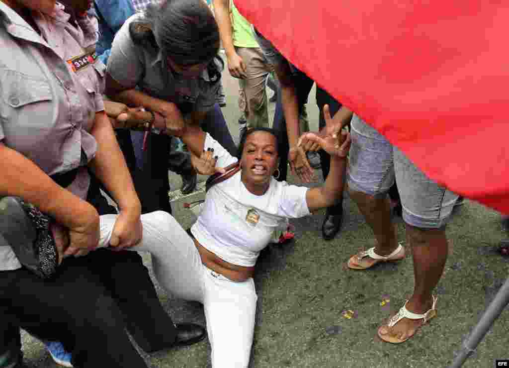Yaquelin Boni, de las Damas de Blanco es detenida, entre hostigamiento e insultos de sectores oficialistas el 10 de diciembre de 2015, en La Habana (Cuba). 