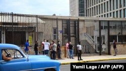 Peloteros cubanos esperan fuera de la Embajada de EEUU para hacer una petición de visa