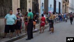 Habaneros hacen fila frente a un mercado para adquirir alimentos. ( YAMIL LAGE/AFP)