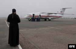 Sacerdote ortodoxo recibe al avión del Ministerio de Situaciones de Emergencia en San Petersburgo.