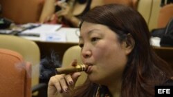 LA HABANA (CUBA), 26/02/2013.- Una mujer fuma un habano mientras escucha al comité organizador del XV Festival del Habano 