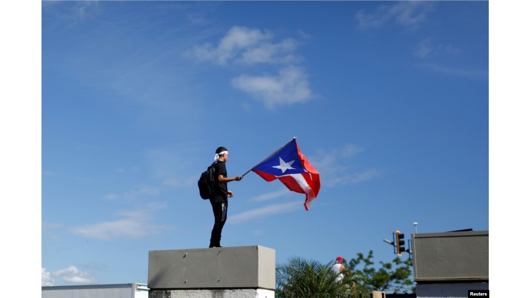 Un hombre ondea la bandera de Puerto Rico durante la protesta de este lunes contra Rosselló.