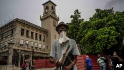 Un peatón con una máscara improvisada, en medio de la pandemia de coronavirus, pasa frente a la Estación Central de Trenes, en La Habana. (AP/Ramón Espinosa)