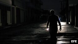 Un hombre camina con una linterna por el barrio de El Cerro, en La Habana, durante un apagón. EFE/Alejandro Ernesto.
