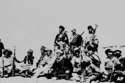 Fotografía de archivo de marzo 1959 del Dalai Lama, sentado al centro, descansando con guerreros que lo protegieron en el Himalaya después de huir de la capital Lhasa.