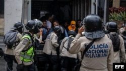 Agentes de la Policía Nacional Bolivariana detienen a manifestantes durante una marcha hacia la sede del Poder Electoral.
