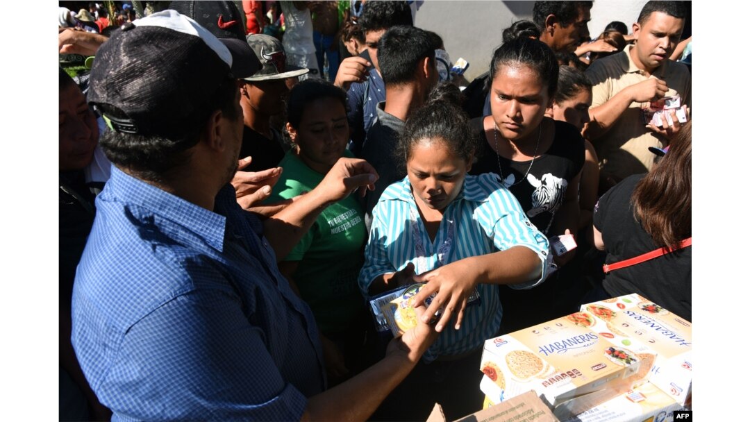 Hondureños que forman parte de la caravana de migrantes reciben comida en una plaza de Tapachula, Chiapas, México.