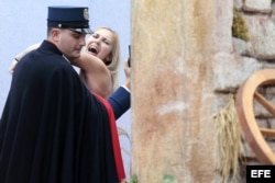 Un miembro de la gendarmería vaticana cubre y detiene a una activista de Femen que intentó llevarse la figura del niño Jesús .