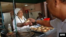Una mujer vende panes con cerdo en un puesto callejero en La Habana (Cuba). 