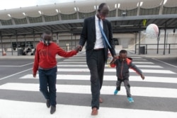 Peter Biar Ajak, con sus hijos, tras llegar al aeropuerto internacional de Washington Dulles, en Virginia, el 23 de julio de 2020