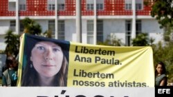 Simpatizantes del grupo ecologista Greenpeace sostienen pancarta con una imagen de la activista brasileña Ana Paula durante una protesta frente a la embajada de Rusia en Brasil