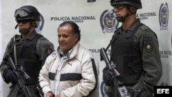 Archivo - Efectivos de la policía colombiana escoltan a Hely Mejía Mendoza (c), destacado cabecilla de las FARC conocido con el alias de 'Martín Sombra', quien fuera capturado en el departamento de Boyacá y presentado hoy, 26 de febrero de 2008, en Bogotá